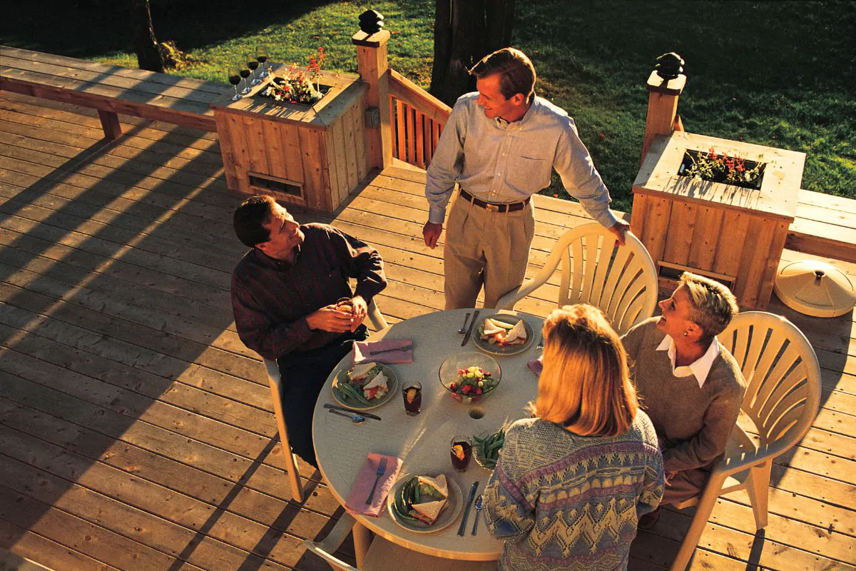 family having meal on backyard deck patio