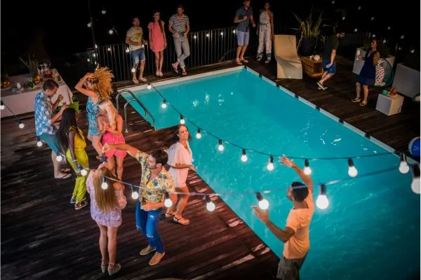 group of friends enjoying pool party in a in ground pool deck