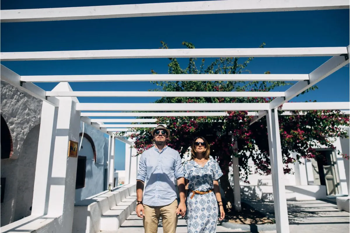 young couple standing under a white pergola