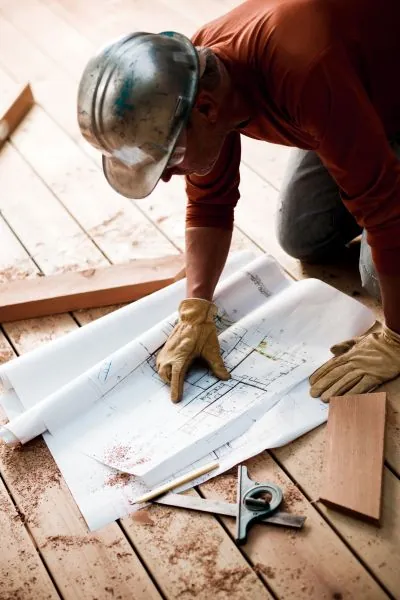 deck builder checking the plan for ground level deck building