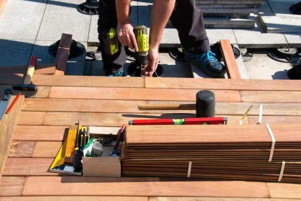 deck contractor using power tools for ground level deck building